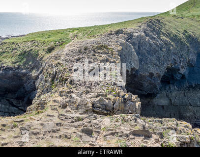 Blick auf die Devil's Bridge von oben auf Worm's Head auf der Gower Peninsula, Wales mit einem schimmernden Meer im Hintergrund Stockfoto