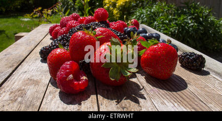 A variety of Summer fruits, on a wooden table in the garden. Stockfoto