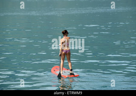 Frau im Bikini Stand up Paddle surfen oder stehend Paddel am Lac d ' Annecy in Frankreich Stockfoto