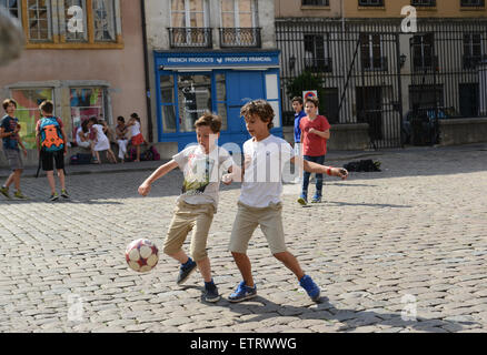 Kinder Jungen Fußball spielen auf gepflasterten Straße in Lyon Frankreich Europa Stockfoto