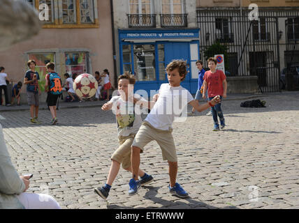 Kinder Jungen Fußball spielen auf gepflasterten Straße in Lyon Frankreich Europa Stockfoto