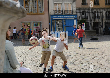 Kinder Jungen Fußball spielen auf gepflasterten Straße in Lyon Frankreich Europa Stockfoto