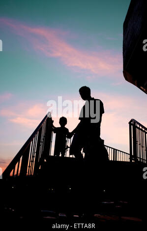 Silhouette Mann und Kind, die Treppe hinunter, im Sonnenuntergang