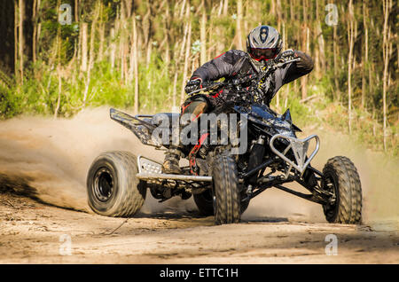 ATV Racer nimmt eine Wendung während eines Rennens auf einem staubigen Gelände. Stockfoto