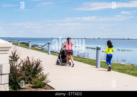 Zwei hispanischen Mädchen schob einen Kinderwagen, gehen Sie in Richtung der Eisenhower-Plaza am Lake Hefner, Oklahoma City, Oklahoma, USA. Stockfoto