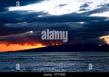 Honolulu, Hawaii. 12. Juni 2015. Orange Sonnenstrahlen hinter den Bergen auf Oahu, Hawaii. Stockfoto