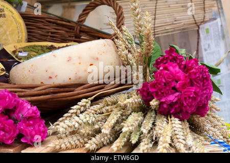 italienische Käse mit Pfeffer im Weidenkorb und Blumen Stockfoto
