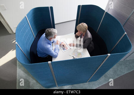 Geschäftsmann und Geschäftsfrau arbeiten in partitionierten Sitzungsraum Stockfoto