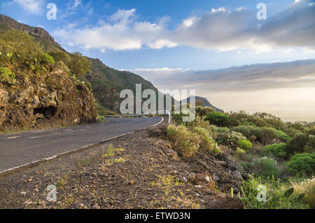 Kurvenreiche Panoramastraße mit Zaun am Sonnenuntergang, Teneriffa, Kanarische Inseln Stockfoto