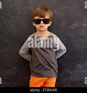 Porträt von unschuldiges kleines Kind das Tragen von Sonnenbrillen. Kleiner Junge stützte sich auf einer Tafel. Quadratische Komposition. Stockfoto