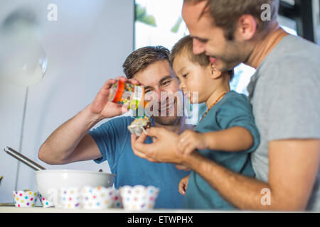 Gay paar backen Kuchen mit Sohn Stockfoto
