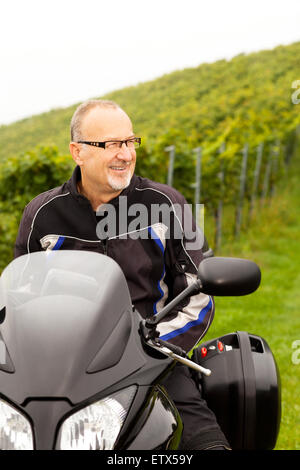 Motorradfahrer sitzen lachend auf dem Fahrrad Stockfoto