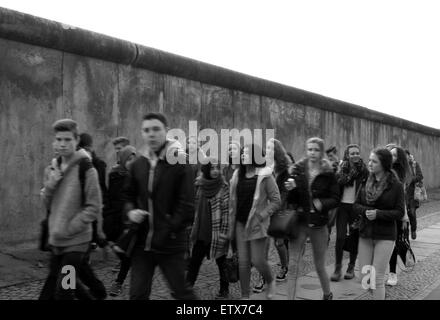 Berlin, Deutschland, ein Teil der ehemaligen Grenzmauer Jugendliche vorbeigehen. Stockfoto