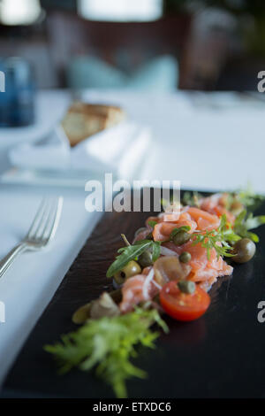 Wurst-Auswahl auch Salami, Chorzio und Parma Schinken. Serviert auf einer schwarzen Tafel mit Brot und Garnitur. Stockfoto