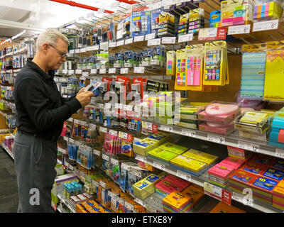 Reifen Sie Mann Überprüfung zeigt im Staples Store, NYC Stockfoto