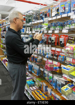 Reifen Sie Mann Überprüfung zeigt im Staples Store, NYC Stockfoto