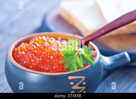 Rot-Lachs-Kaviar in Schüssel geben und auf einem Tisch Stockfoto