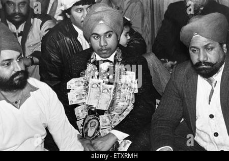 Ein Service für 18 jährige Jaspal Singh feiert seine Verlobung mit Geschenken Geld von anderen Gläubigen bilden einen Kranz um den Hals an den Guru Nanak Sikh-Tempel. 17. Februar 1988 Stockfoto