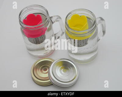 Der Hersteller Tee in ein Glas Wasser auf einem weißen Hintergrund. Stockfoto