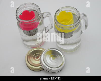 Der Hersteller Tee in ein Glas Wasser auf einem weißen Hintergrund. Stockfoto