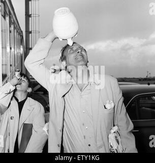 Spike Milligan und Familie zurück von einem dreiwöchigen Urlaub in Marbella, Flughafen London abgebildet. Spike mit einer Flasche Wasser, die er aus Spanien und sein Sohn Sean (10) haben. 6. September 1965 Stockfoto