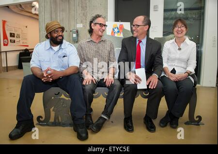 US Secretary Of Labor Thomas Perez spricht mit Künstler James Simon (Mitte links), Schweißer Ramone Patterson (links) und Projektleiter Karen Antonelli (rechts), wie sie auf einer Bank die drei 29. Mai 2015 in der Mitte für Hochregallager Robotics planetarischen Robotik an der Carnegie Mellon University in Pittsburgh, Pennsylvania gemacht sitzen. Stockfoto