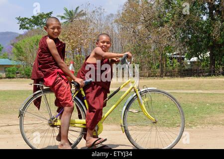 Zwei junge burmesische Mönche auf dem Fahrrad in einem Dorf am Inle Lake, Burma, Myanmar, Südostasien Stockfoto