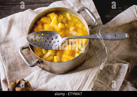 Mango-Chutney oder Marmelade in Vintage Aluminium über alten Holztisch mit ganzen und in Scheiben schneiden Mangostan pan machen. Dunkle, rustikale Atmosphäre Stockfoto