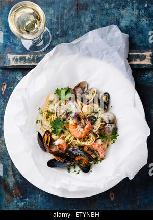 Pasta mit Meeresfrüchten und Wein - "Spaghetti mit Muscheln, Garnelen, Muscheln" auf blauem Hintergrund Stockfoto