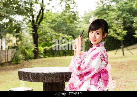 Asiatische Frau in Jpanese Garten halten fan Stockfoto