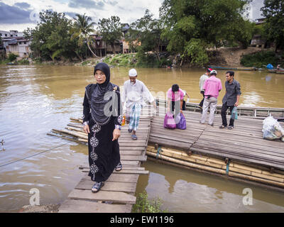 Sungai Kolok, Narathiwat, Thailand. 16. Juni 2015. Menschen aus Malaysia bekommen von einem kleinen Boot auf der thailändischen Seite der Grenze. Die Grenze zwischen Thailand und Malaysia in Sungai Kolok, Narathiwat, Thailand. Thai und Malaysier Grenze die frei für Einkaufs- und Familien besucht. Die Grenze ist der Kolok Fluss © Jack Kurtz/ZUMA Draht/Alamy Live News Stockfoto