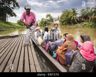 Sungai Kolok, Narathiwat, Thailand. 16. Juni 2015. Menschen aus Malaysia bekommen von einem kleinen Boot auf der thailändischen Seite der Grenze. Die Grenze zwischen Thailand und Malaysia in Sungai Kolok, Narathiwat, Thailand. Thai und Malaysier Grenze die frei für Einkaufs- und Familien besucht. Die Grenze ist der Kolok Fluss © Jack Kurtz/ZUMA Draht/Alamy Live News Stockfoto