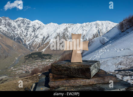 Kleines Steinkreuz neben Holy Trinity Church (Tsminda Sameba) aus dem 14. Jahrhundert in der Nähe von zurGergeti Dorf, Georgien Stockfoto