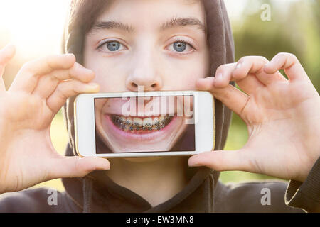 virtuelle Immobilien, Teenager, die eine Smartphone vor seinem Gesicht halten Stockfoto