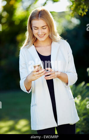Mädchen lesen Nachricht auf ihrem iPhone Stockfoto
