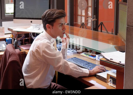 An der Rezeption eines Hotels im historischen Zentrum der Stadt San Cristobal de La Laguna, das zum UNESCO-Weltkulturerbe im nördlichen Teil der Kanarischen Insel Teneriffa, Spanien, erklärt wurde, arbeitet ein Rezeptionist an einem Computer Stockfoto