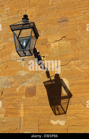 Laterne mit knackigen Schatten gegen die orange Eisenstein die Stallungen in Althorp House, Heimat von Earl Spencer Stockfoto