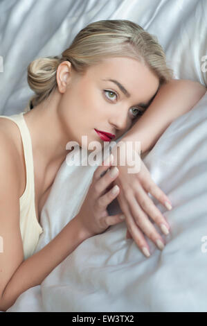 Schöne junge Frau im Bett Stockfoto