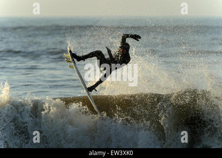 Eingehüllt in Spray Surfer, fliegen frei von dem Wappen der brechenden Welle mit Armen hoch, Surfen auf Gower in Wales gehalten. Stockfoto