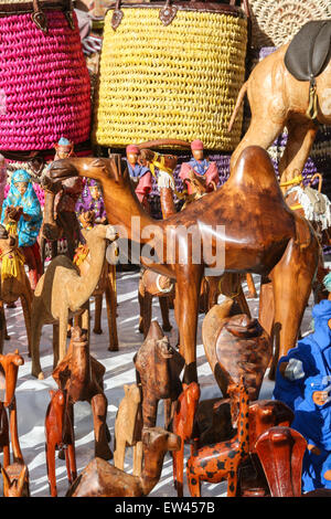 Hölzerne Kamele und Tuareg Souvenirs an diesem touristischen Stand bei La Criee Berbere, Teppich-Bereich in den Souk in Marrakesch, Marokko, Stockfoto