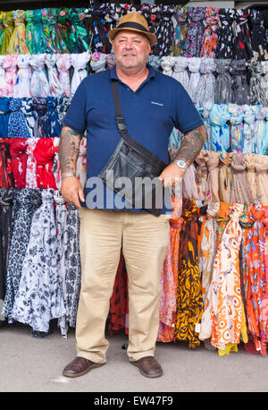 Standinhaber mit bunten Schals für den Verkauf auf Marktstand in Dorchester, Dorset, Großbritannien im Juni Stockfoto