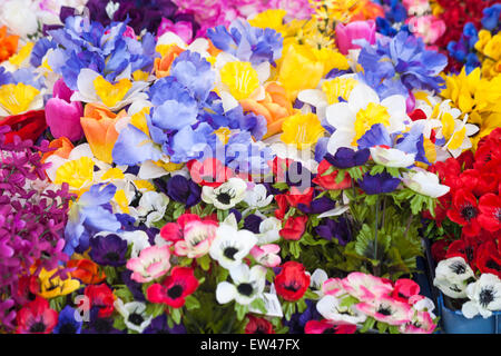 Kunstkunststoffblumen zum Verkauf am Marktstand in Dorchester, Dorset, Großbritannien im Juni Stockfoto