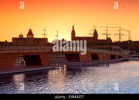 Sonnenuntergang über der Skyline von Szczecin (Stettin) mit Silhouetten von Gebäuden und Schiffen, Polen. Stockfoto