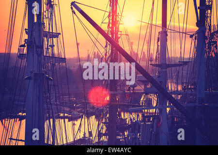 Vintage getönten Sonnenaufgang über dem Hafen, Segelboote Masten, Lens-Flare-Effekt. Stockfoto