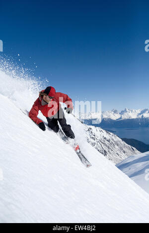 Telemark-Skifahrer Will Wacker Ski steilen Berg hinunter am sonnigen blauen Himmel Tag in Alaska Backcountry. Stockfoto