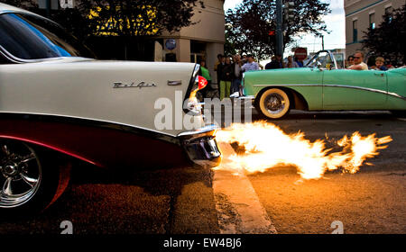 Zuschauer stehen entlang einer Straße, die gerade eines Oldtimers mit einem flammenden Auspuff in Coeur d ' Alene, Idaho. Stockfoto