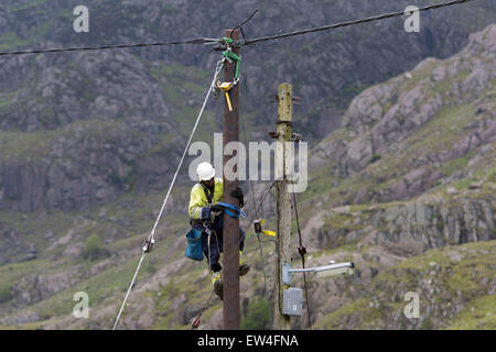 Ein Ingenieur führt Wartungsarbeiten an ein Strom Strommast im ländlichen Norden von Wales. Stockfoto