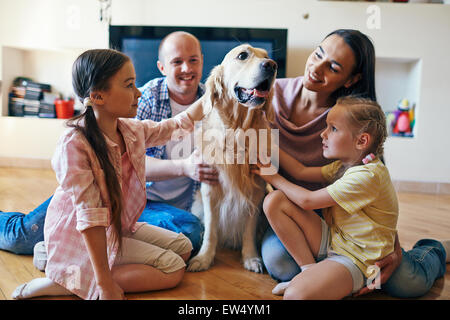 Haustier, umgeben von vierköpfige Familie auf sofa Stockfoto
