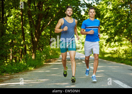 Zwei Freunde auf eine Joggingstrecke durch den Wald laufen Stockfoto
