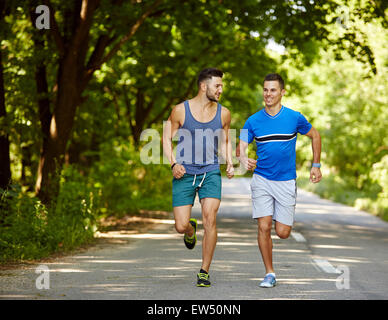 Zwei Freunde auf eine Joggingstrecke durch den Wald laufen Stockfoto